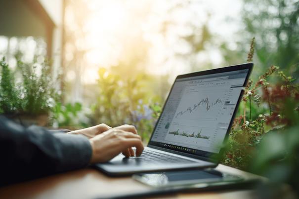 Afbeelding van iemand die duurzaam geïnvesteerd is. Hij kijkt op de laptop naar de winst.
